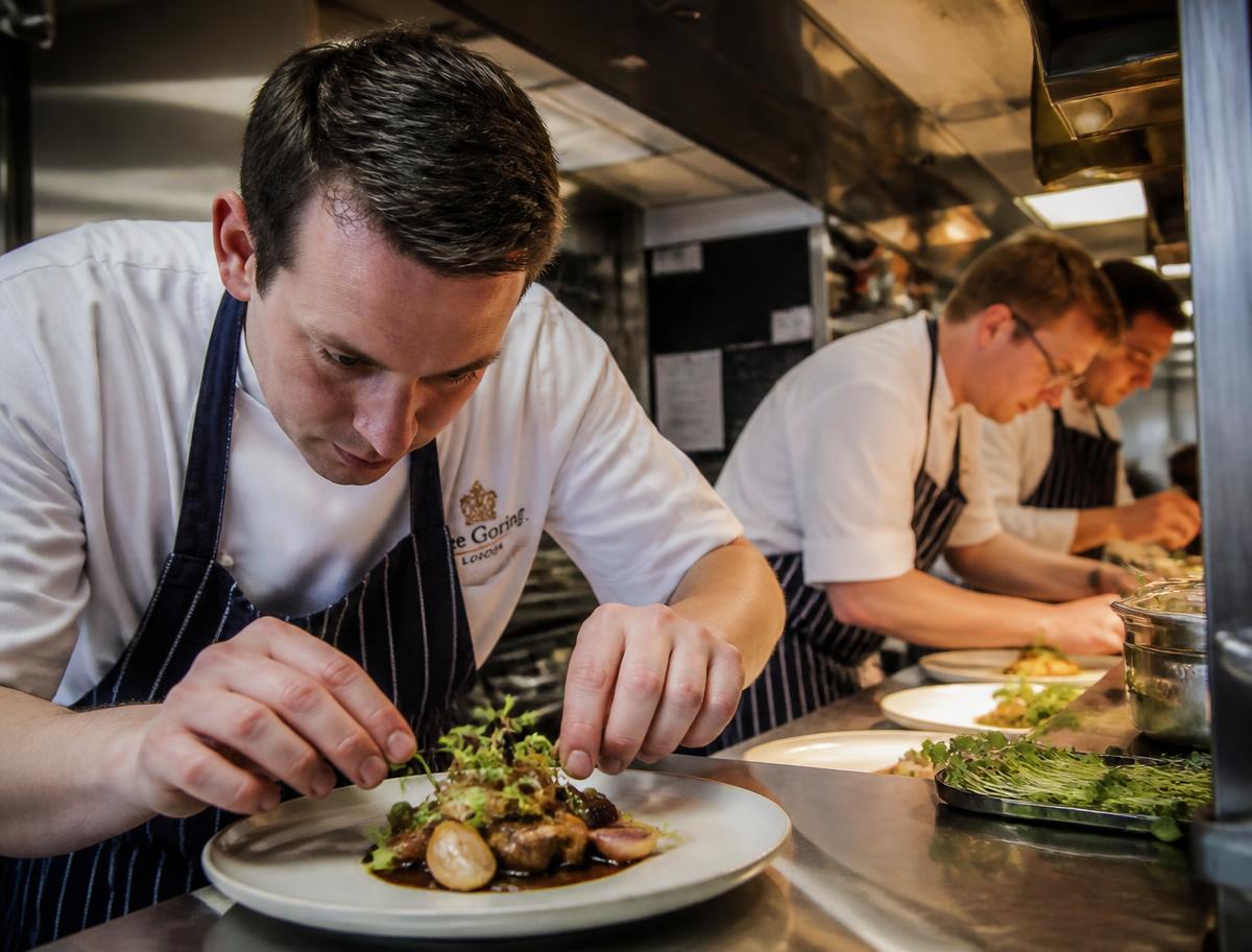Chefs plating dishes in a hotel kitchen